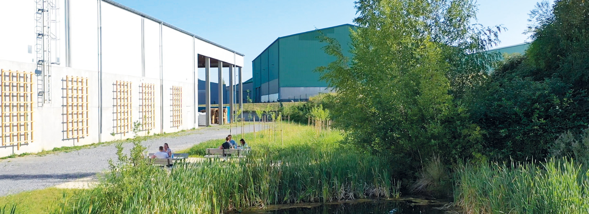 Foto des Betriebsgeländes mit Teich und Sitzmöglichkeiten für Mitarbeiter