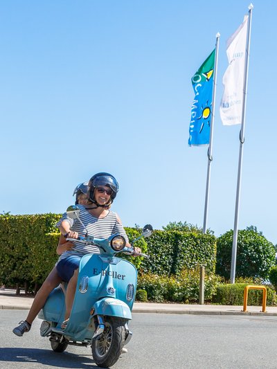 Zwei Urlauber auf einem E-Motorroller des Inselcamp Fehmarn. 