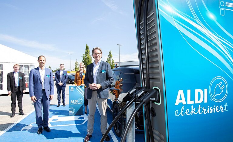 Bundesverkehrsminister Andreas Scheuer neben einer Elektro-Ladesäule auf einem Parkplatz von Aldi Süd.
