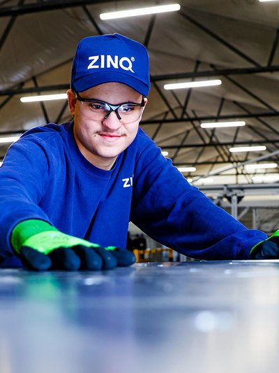 Foto von ZINQ-Mitarbeiter, der über eine Stahloberfläche streicht