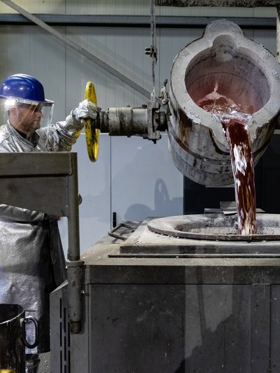 Gießprozess von WE-EF. Arbeiter vor Gießkessel.