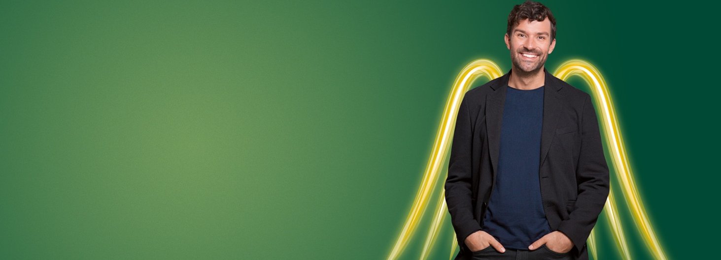 Foto von einem Mann vor grünem Hintergrund mit gelben Engelsflügeln