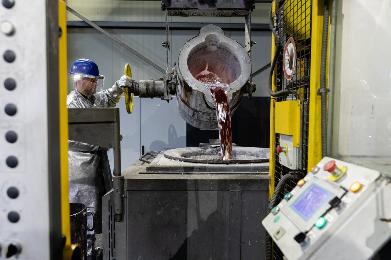 Gießprozess von WE-EF. Arbeiter vor Gießkessel.