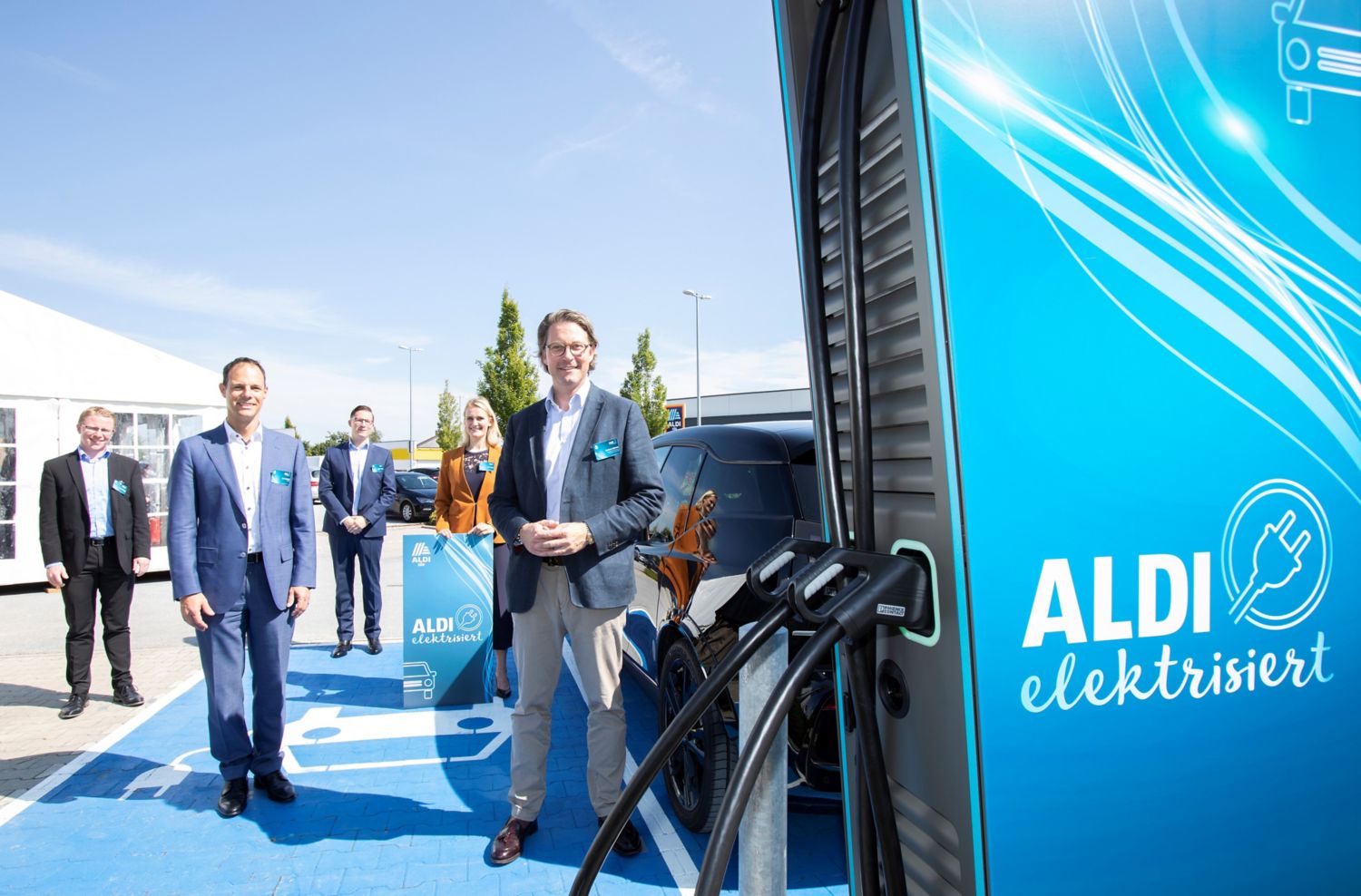 Bundesverkehrsminister Andreas Scheuer neben einer Elektro-Ladesäule auf einem Parkplatz von Aldi Süd.